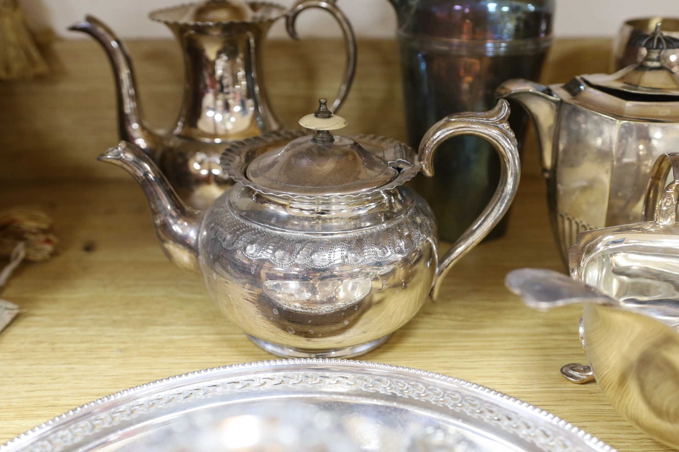 A quantity of assorted plated wares including a chamberstick, a tea set, flatware, a cocktail shaker, a sauceboat, goblets, etc.